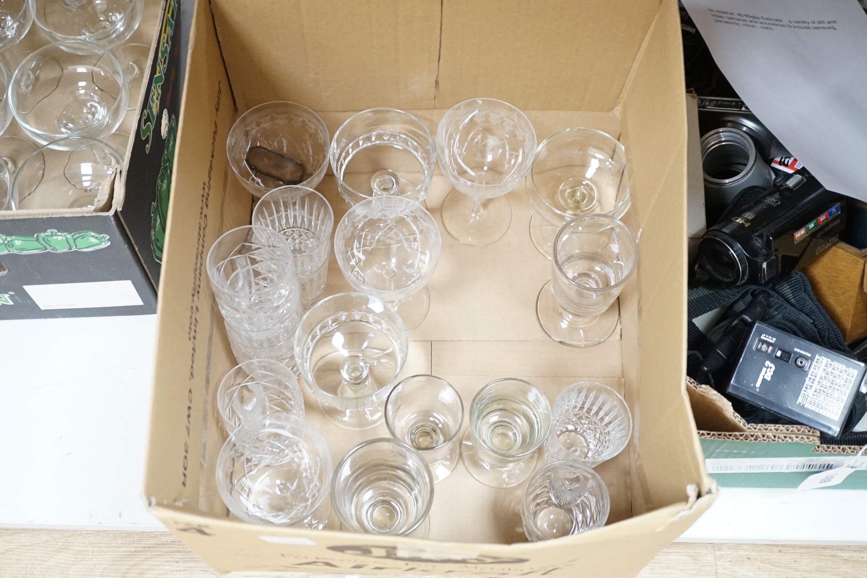 A collection of glassware including nine coupe glasses etched with butterflies and leaves